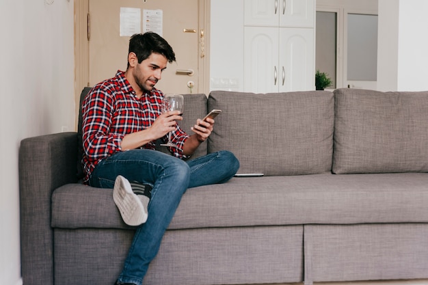 Photo gratuite homme avec du vin sur le canapé