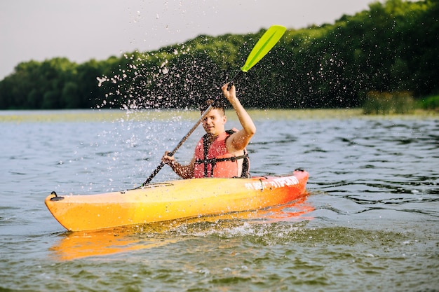 Homme, éclabousser, eau, à, pagaie, pendant, kayak, sur, lac