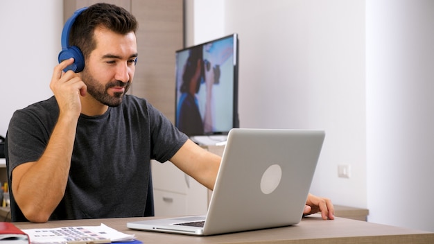 Homme écoutant de la musique avec ses écouteurs au bureau. Bonne ambiance