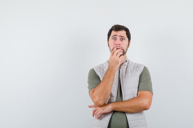 L'homme effrayé tient sa main droite à la bouche sur fond blanc