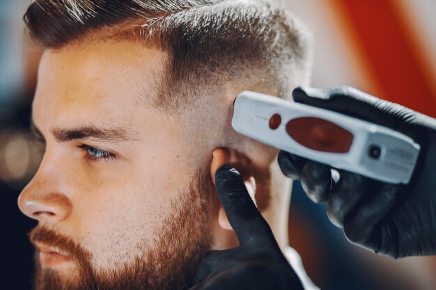 Homme élégant assis dans un salon de coiffure