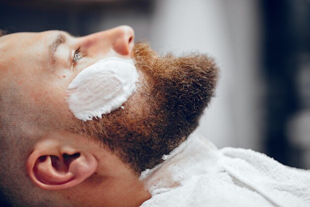 Homme élégant assis dans un salon de coiffure