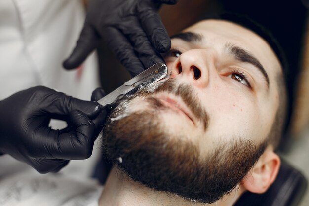 Homme élégant assis dans un salon de coiffure