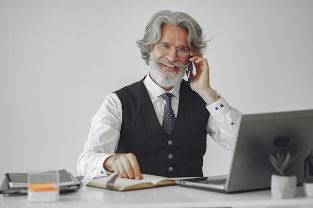 Photo gratuite homme élégant au bureau. homme d'affaires en chemise blanche. l'homme travaille avec le téléphone.