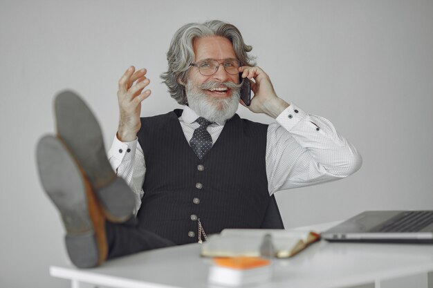 Homme élégant au bureau. Homme d'affaires en chemise blanche. L'homme travaille avec le téléphone.