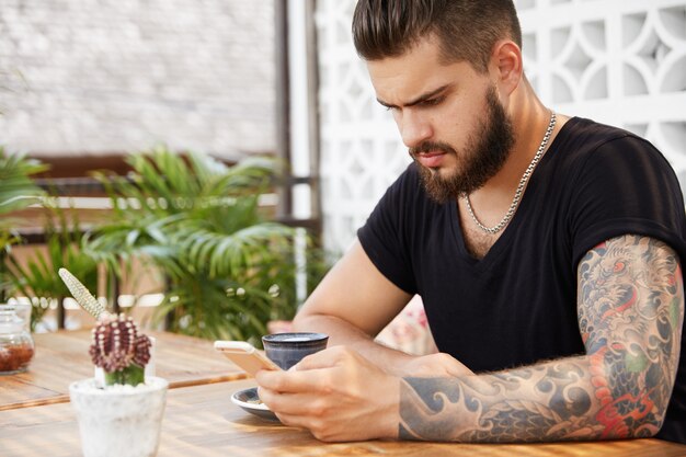 Homme élégant barbu assis dans un café