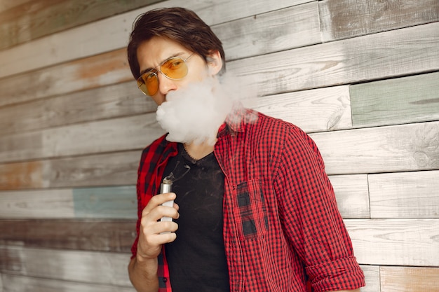 Photo gratuite homme élégant et élégant dans une ville avec vape