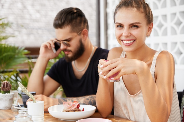 Homme élégant et femme assise dans un café