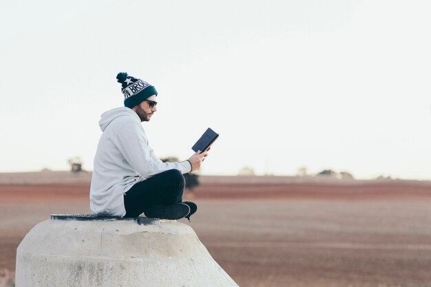 Homme élégant hipster avec tablette à l&#39;extérieur