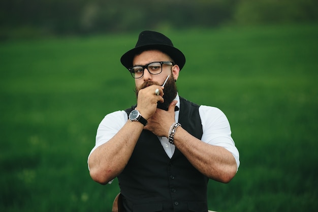 homme élégant posant avec chapeau