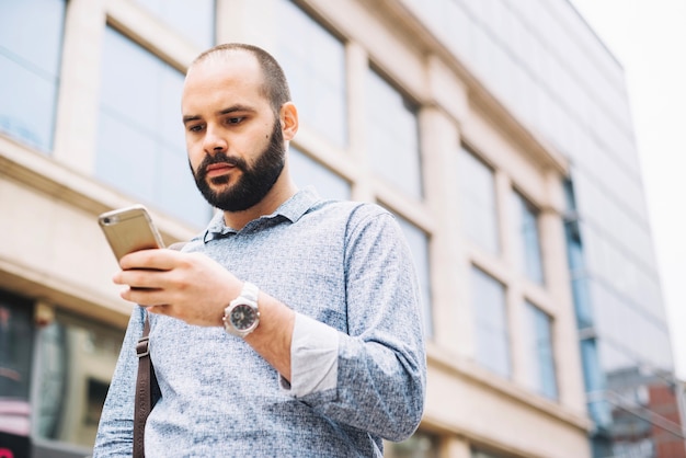 Homme élégant sérieux, regarder le téléphone