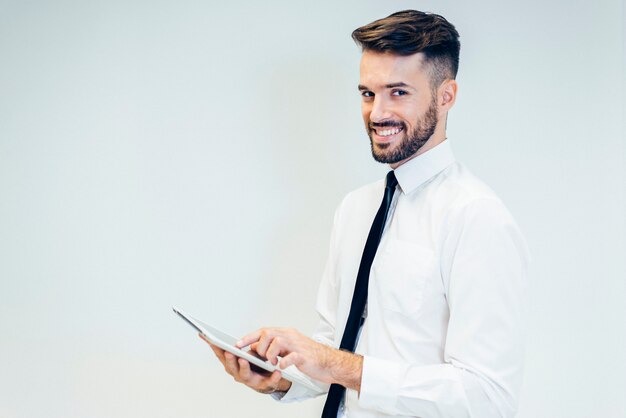 homme élégant sourire tout en regardant une tablette