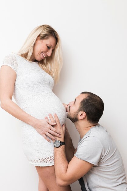 Homme embrassant une femme enceinte