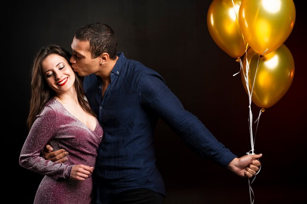 Homme embrassant femme à la fête du nouvel an