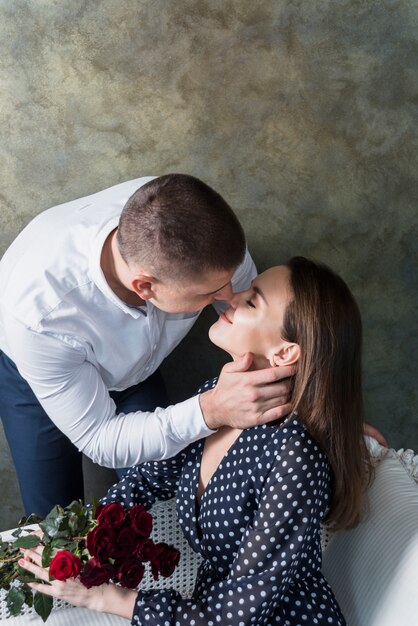 Homme embrassant une femme avec des fleurs