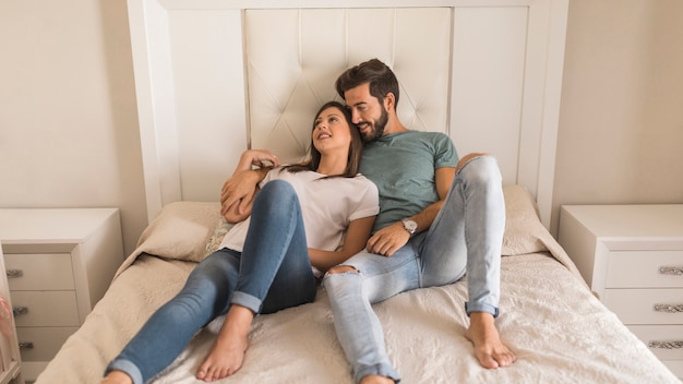 Homme embrassant une femme sur son lit