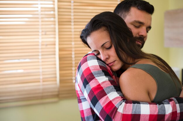 Homme embrassant sa femme à la maison