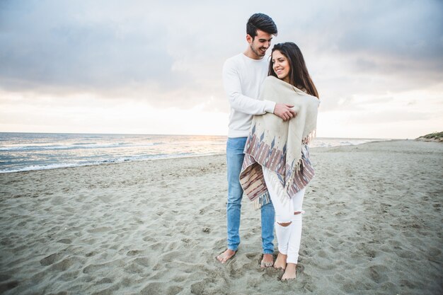 Homme embrassant sa petite amie sur la plage