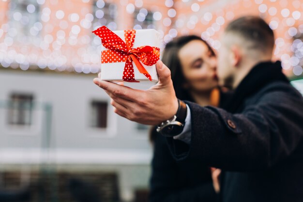 Homme embrasse avec femme montrant le cadeau