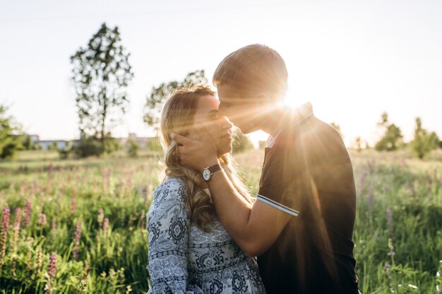 Homme embrasse sa femme enceinte tendre debout dans le champ de lavande