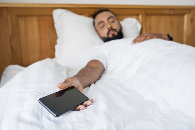 Photo gratuite homme endormi après avoir passé du temps sur son téléphone