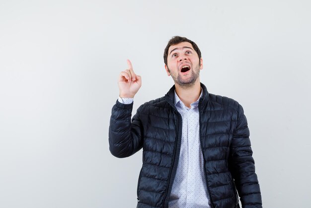 L'homme est surprenant en pointant avec son index sur fond blanc