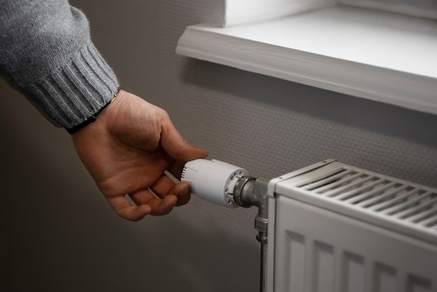 Photo gratuite homme éteignant le radiateur pendant la crise énergétique