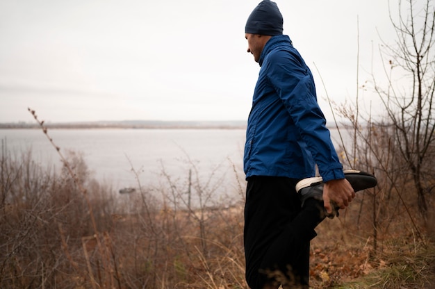 L'homme étire ses jambes en forêt