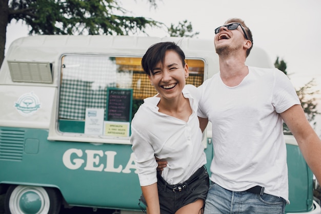 Photo gratuite l'homme étreint et embrasse une femme étonnante devant un autobus