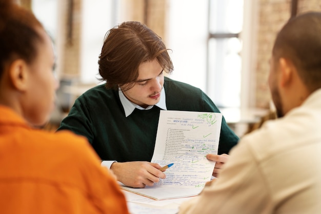 Photo gratuite homme étudiant la grammaire avec ses collègues