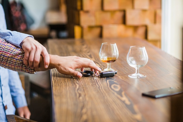 Homme évitant son ami pour prendre les clés de la voiture sur la table