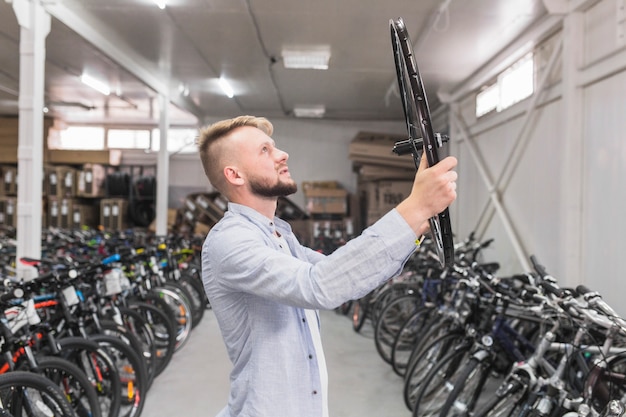 Homme, examiner, jante vélo, dans magasin