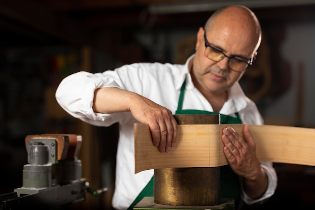 Homme fabriquant des instruments dans son atelier