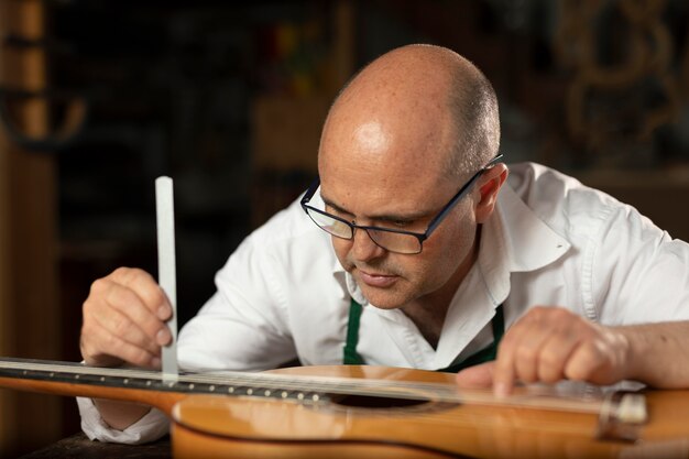 Homme fabriquant des instruments dans son atelier