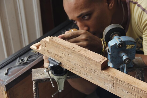 Homme fabriquant des planches de bois à l'intérieur sur une table