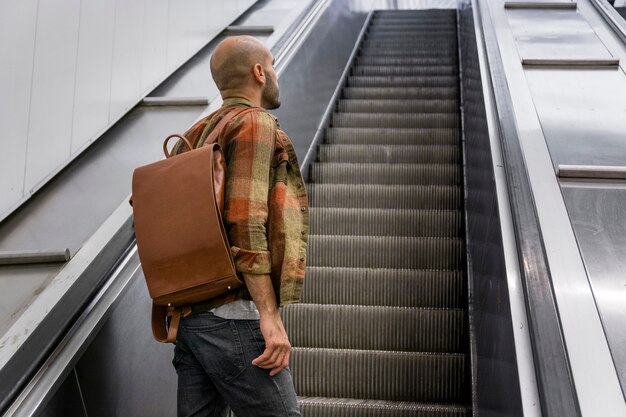 Homme faible angle sur un escalier mobile