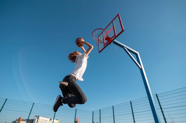 Homme à faible angle jouant au basket