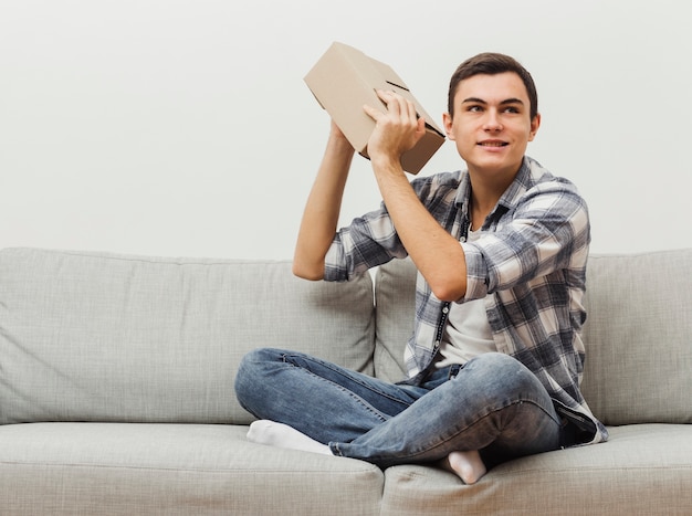 Homme de faible angle secouant la boîte de livraison