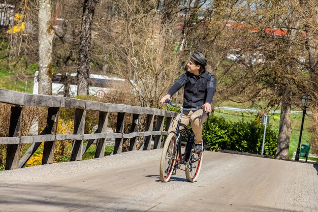Homme, faire du vélo sur le pont en bois et profiter de son voyage