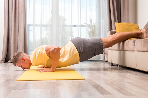 Homme faisant du fitness à la maison à l'aide de canapé