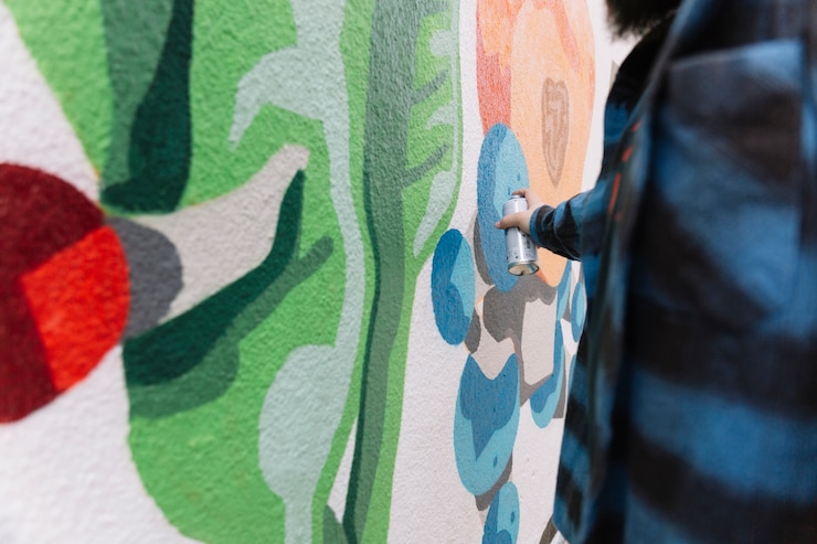 Photo gratuit homme faisant des graffitis avec aérosol sur le mur