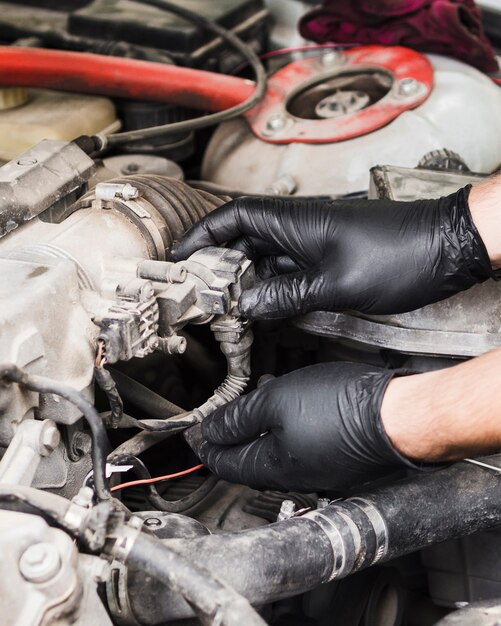 Homme faisant des réparations sur le moteur d'une voiture