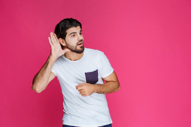 Homme faisant signe qui veut bientôt entendre la personne adverse.