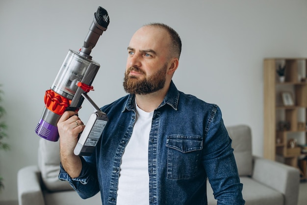 Photo gratuite homme faisant le travail de maison avec l'aspirateur d'accumulateur