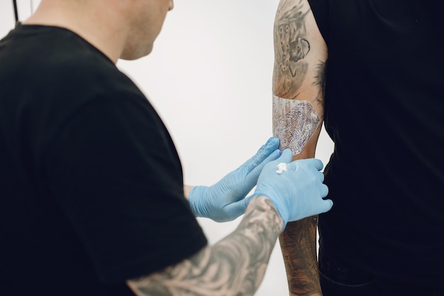 Homme fait un tatouage dans un salon de tatouage