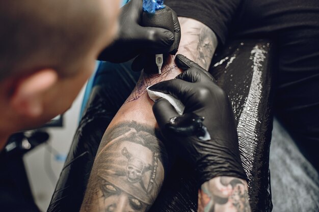 Homme fait un tatouage dans un salon de tatouage