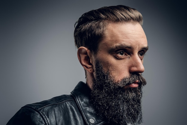 Un homme fatigué et séduisant au studio photo pose pour le photographe sur fond clair.