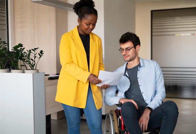 Homme en fauteuil roulant au travail vue de face