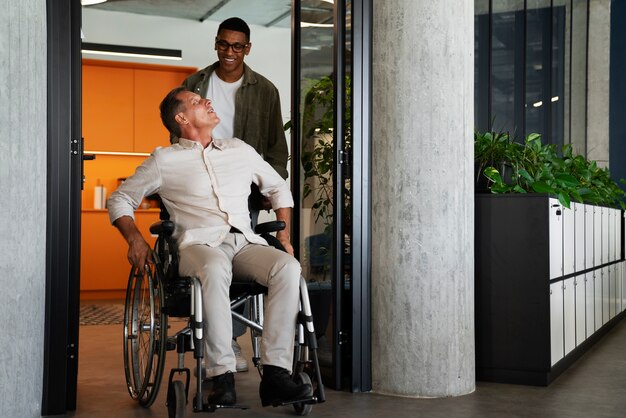 Homme en fauteuil roulant ayant un travail de bureau inclusif