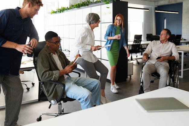 Homme en fauteuil roulant ayant un travail de bureau inclusif